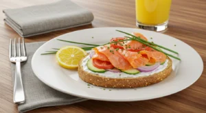 New York Breakfast with toast, cream cheese, smoked salmon, and fresh vegetables garnished with chives.